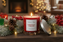 Load image into Gallery viewer, A lit red candle in a clear glass jar sits on a wooden table surrounded by holiday greenery, pinecones, red berries, wrapped gifts, and warm string lights. The candle label reads 'Walter & Rose' and 'Christmas Forever'.
