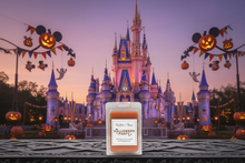 Load image into Gallery viewer, A wax candle in a white rectangular package sits on a wooden surface in front of a Disney castle at dusk, with Halloween decorations, jack-o'-lanterns, and Mickey Mouse head banners framing the scene.